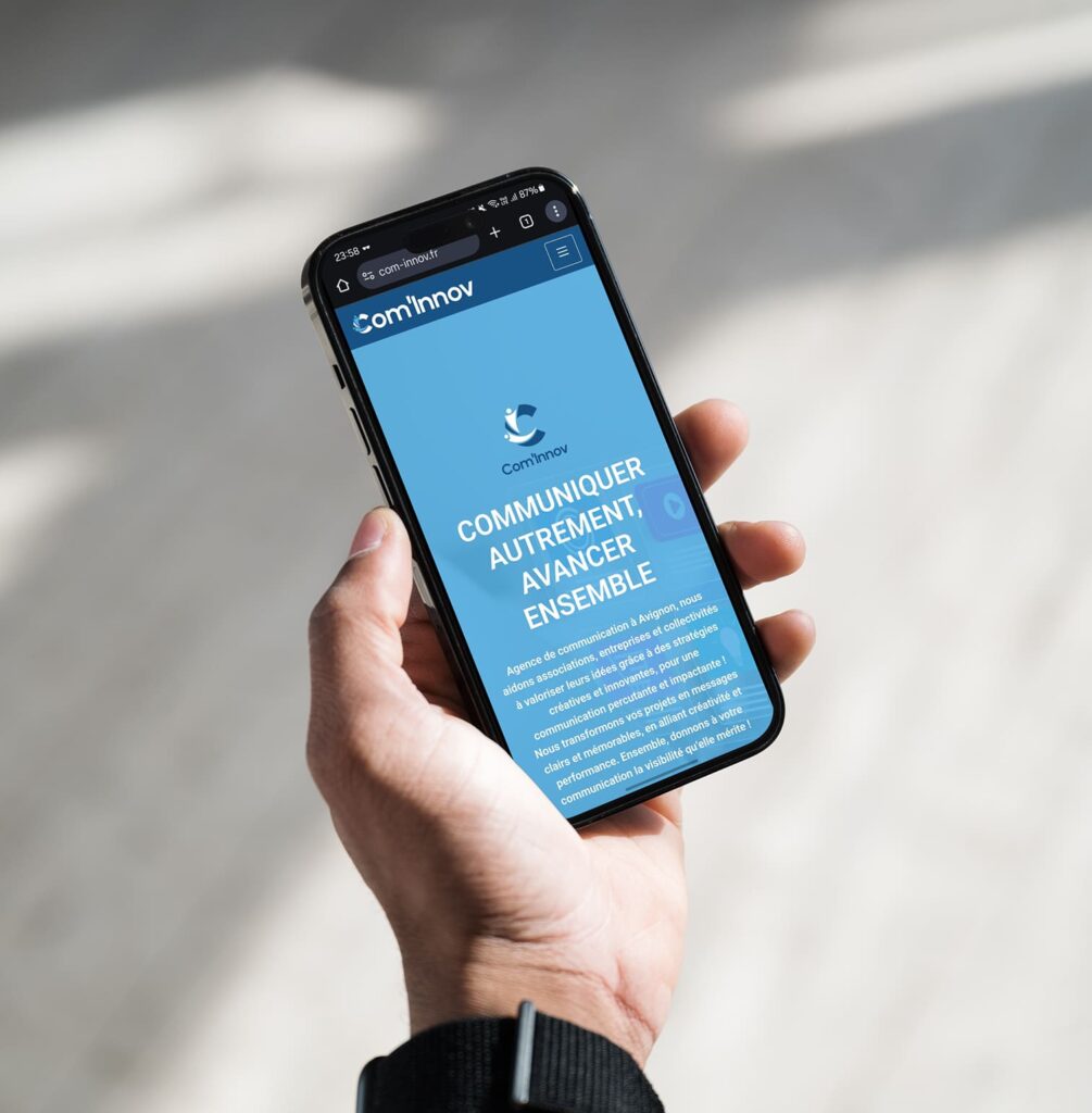 Présentation du site Com’Innov sur smartphone, illustrant la compatibilité mobile et la cohérence visuelle créée par PA Design.